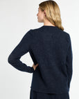 Woman wearing a navy blue sweater against a white background