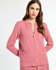 Woman wearing a pink textured jacket and skirt set on a white background