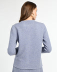 Woman wearing a gray cardigan on a white background