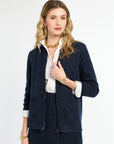 Woman wearing a navy blazer over a white shirt on a white background