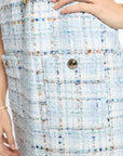 Close-up of a textured fabric with a button, likely from a garment.