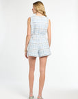 Woman wearing a light blue plaid romper on a white background
