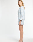 Woman wearing a light blue checkered suit on a white background