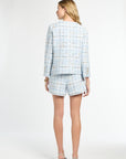 Woman wearing a light blue plaid suit on a white background