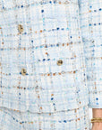 Close-up of a textured fabric with buttons on a light blue background