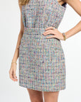 Multicolored patterned dress worn by a person on a white background