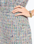 Multicolored textured fabric with a hand wearing a ring and bracelet on a white background