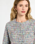 Woman wearing a multicolored textured top against a white background