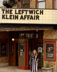 Woman standing in front of a theater with 'The Leftwich Klein Affair' marquee