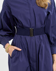Navy blue dress with a belt worn by a person on a white background
