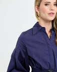 Woman wearing a navy blue outfit with a white background