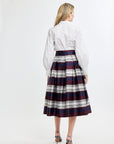 Woman wearing a white shirt and plaid skirt on a white background