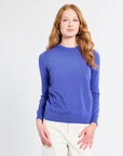 Woman wearing a royal blue sweater on a white background