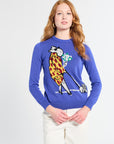 Person wearing a blue sweater with a painted character design on a plain background