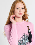 Woman wearing a pink sweatshirt with a knitted design on a white background