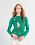 Woman wearing a green sweater with a giraffe design on a white background