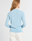 Woman wearing a light blue sweater on a white background