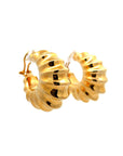 A pair of scalloped gold hoop earrings on a white background.