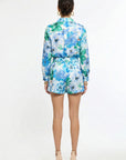 back of woman wearing matching green and blue floral shirt and short set