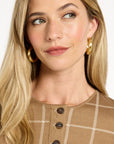 Close-up of the chestnut windowpane plaid pattern and dark buttons of the Reversible Knit Jacket, photographed against a plain white studio background.