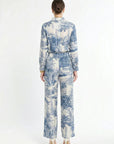 Back of woman wearing white and navy matching set on a white background