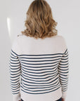 Back view of EL wearing the Perfect Striped Crewneck in cream with navy mariner stripes, paired with dark denim against a white background.
