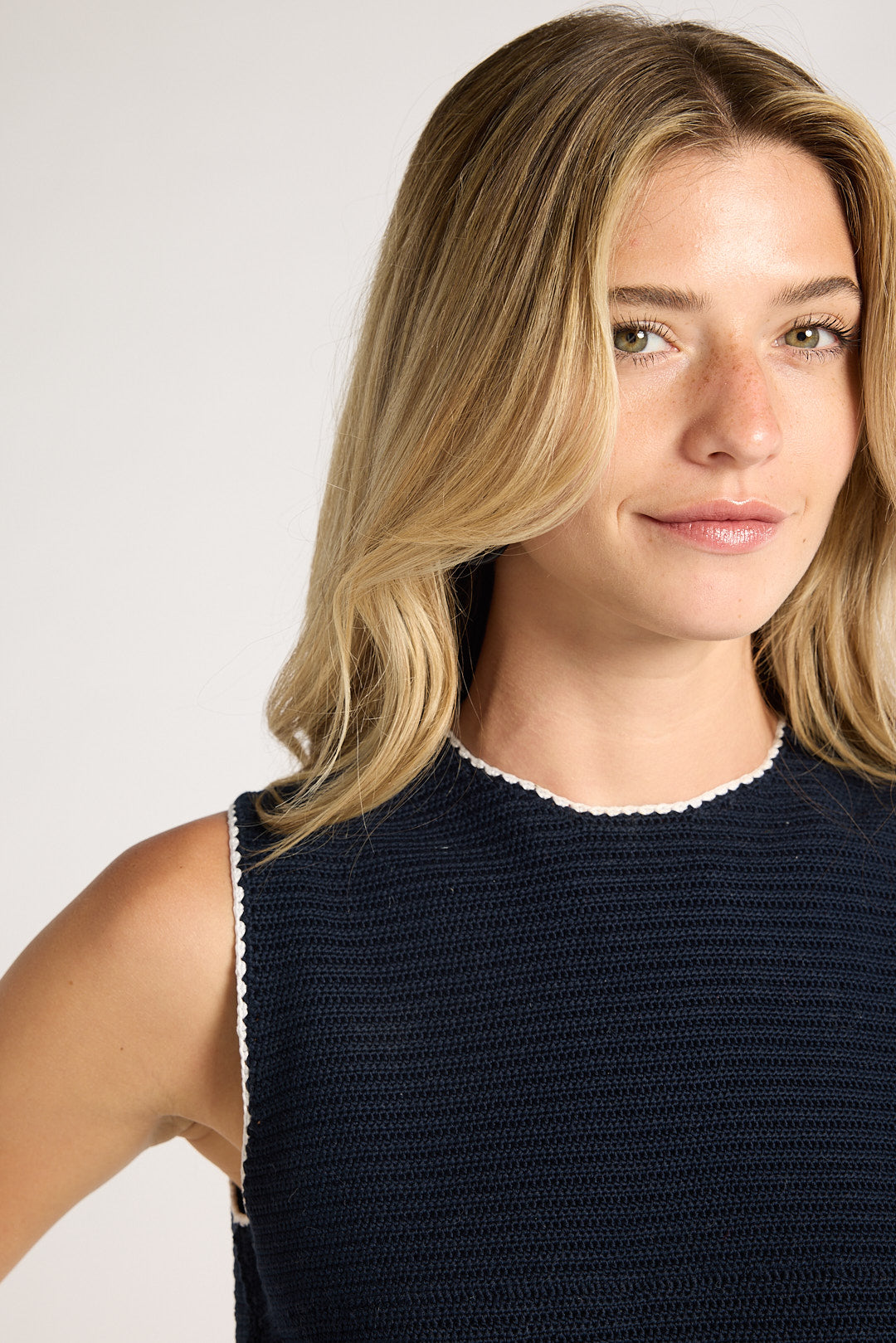 Close up of black material on collar and shoulder of blonde woman