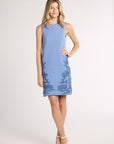 Woman modeling a blue hand-crochet dress with blue fern embroidery on a white background