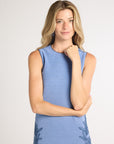 A woman modeling a sleeveless blue hand-crochet dress on a white background