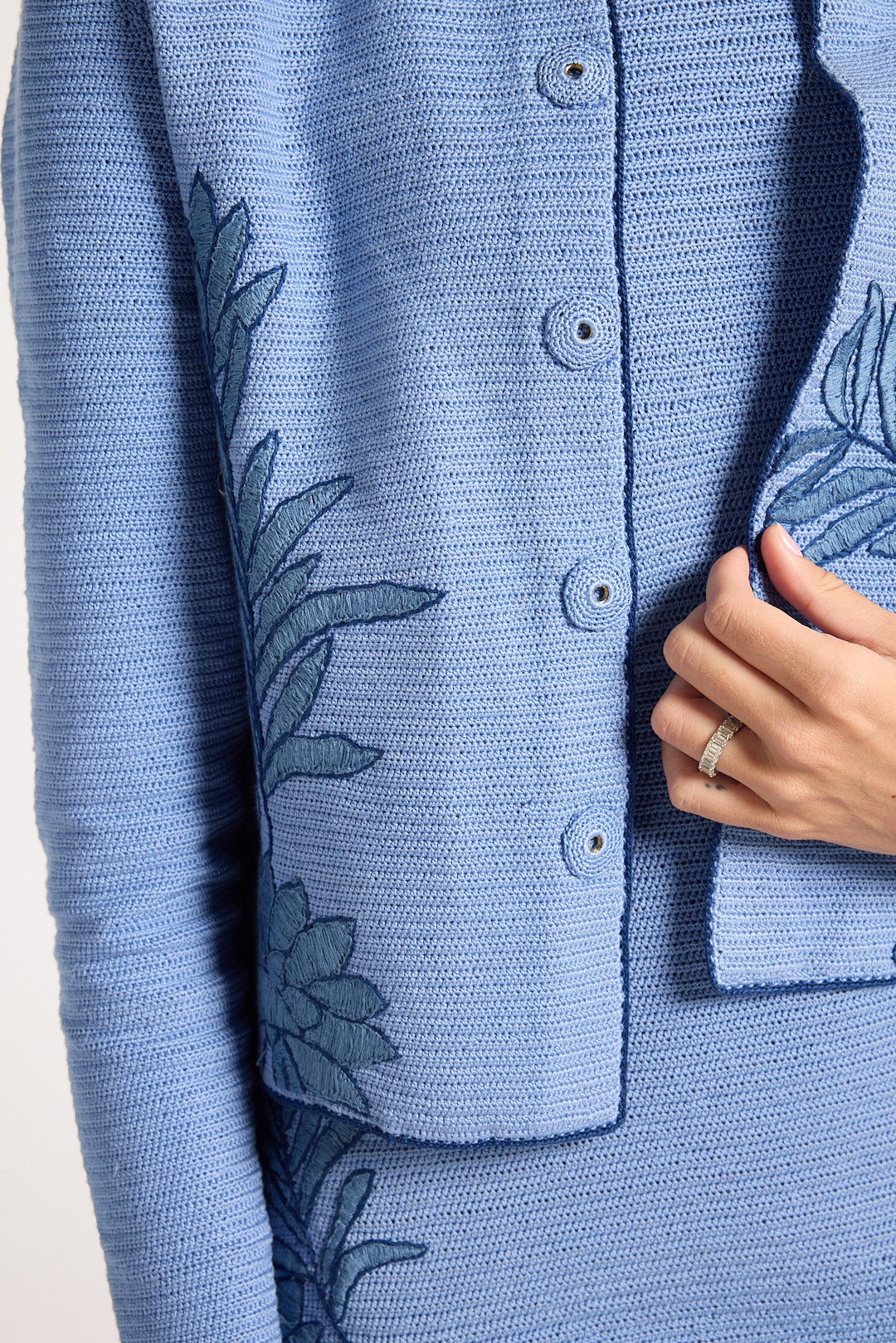 Close up of hand-crochet jacket with blue fern detailing