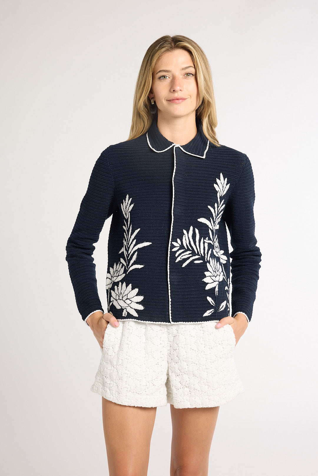 Woman modeling a black jacket with white fern detailing