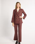 Woman wearing a burgundy blazer in a studio