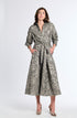 Woman wearing a long, gray brocade patterned dress on a white background
