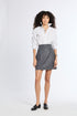Person wearing a white shirt and gray skirt on a white background