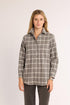 Woman wearing a plaid shirt on a plain background