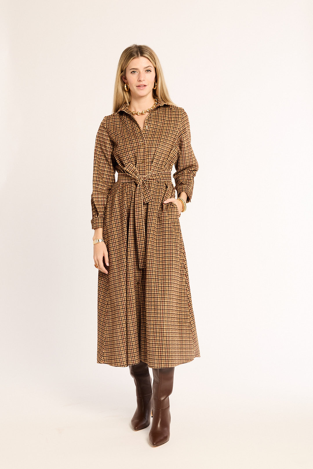 Woman wearing a brown checkered coat on a white background