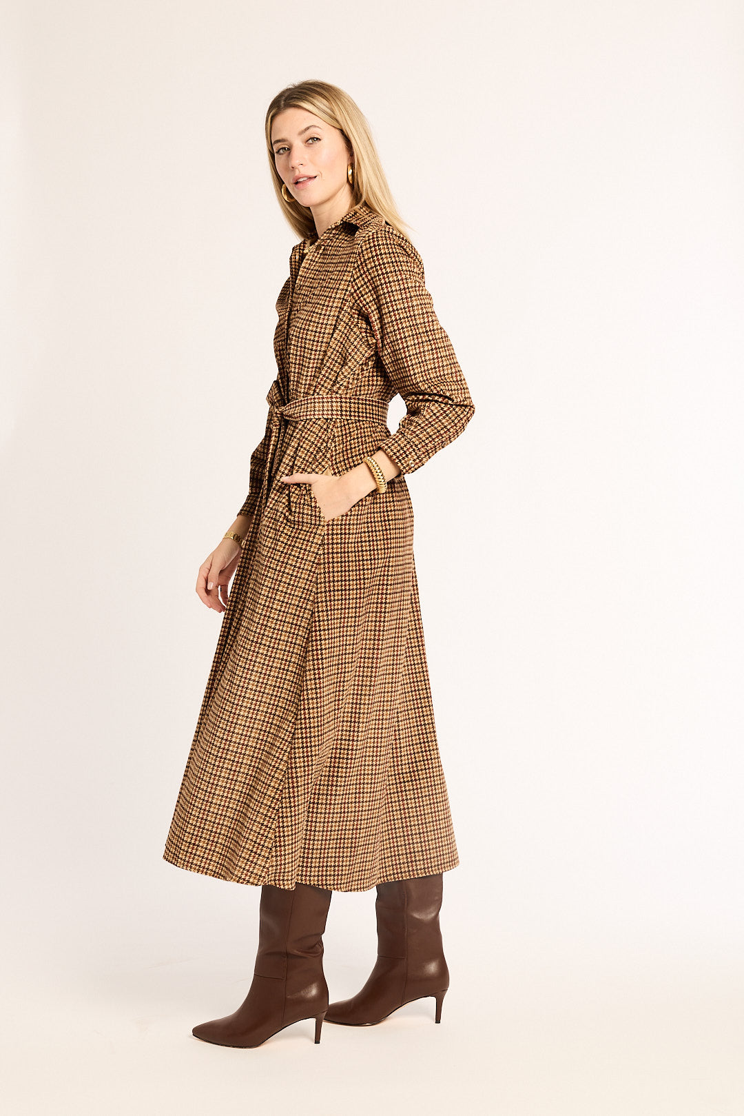 Woman wearing a brown checkered dress with a belt on a white background