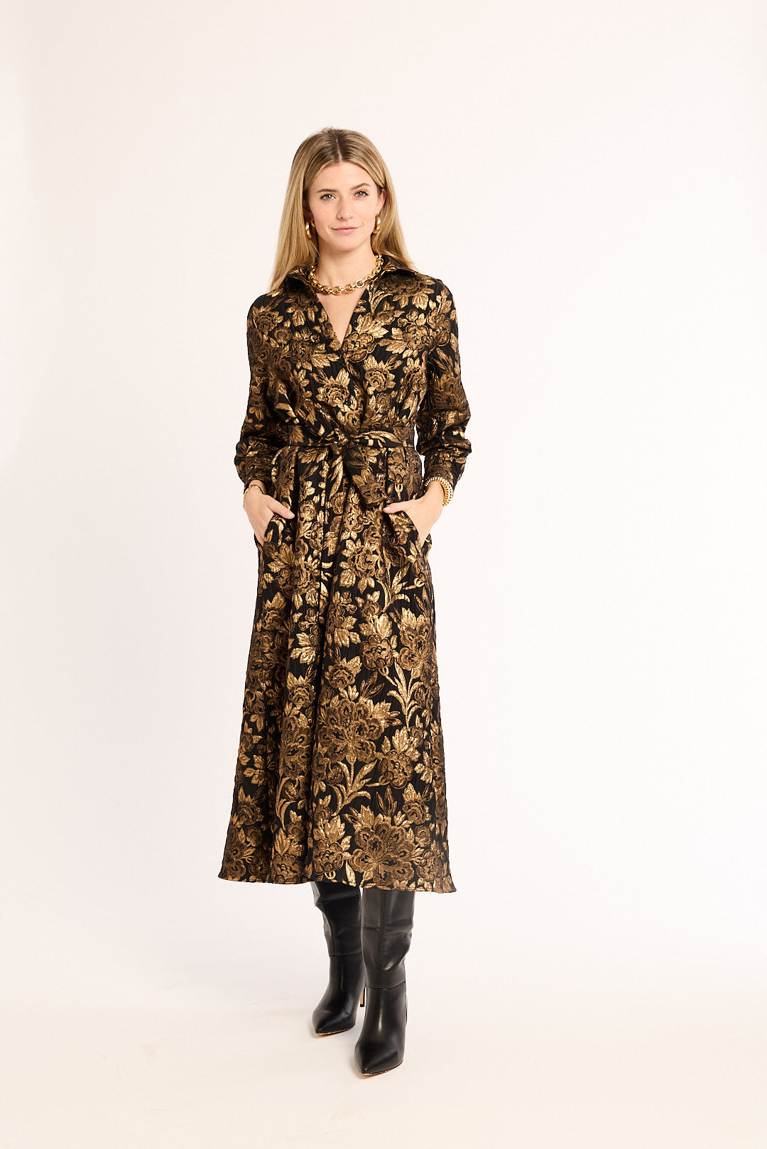 Woman wearing a long, patterned dress with a white background