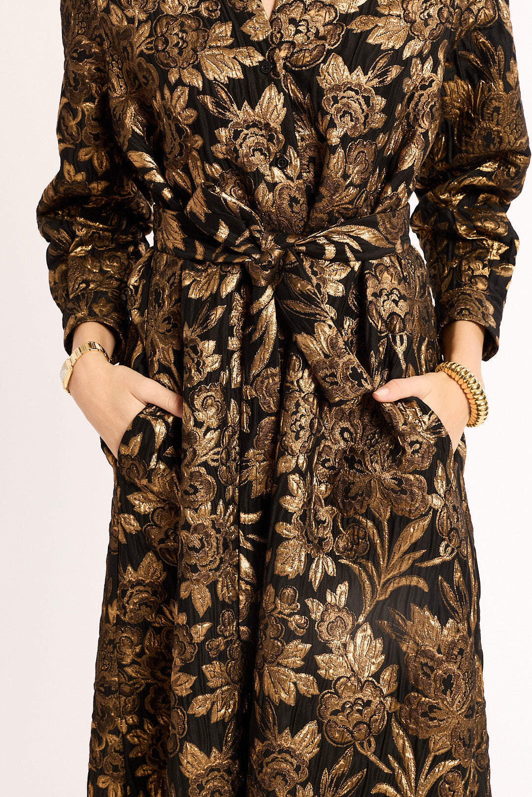 Floral patterned dress with a belt on a plain background