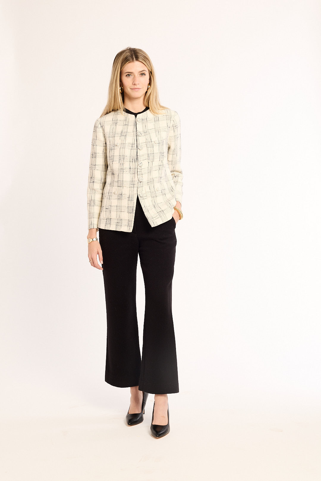 Woman wearing a plaid shirt and black pants on a white background