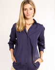 Woman wearing a navy shirt with a plain background