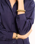 Navy blue shirt with gold jewelry on a white background