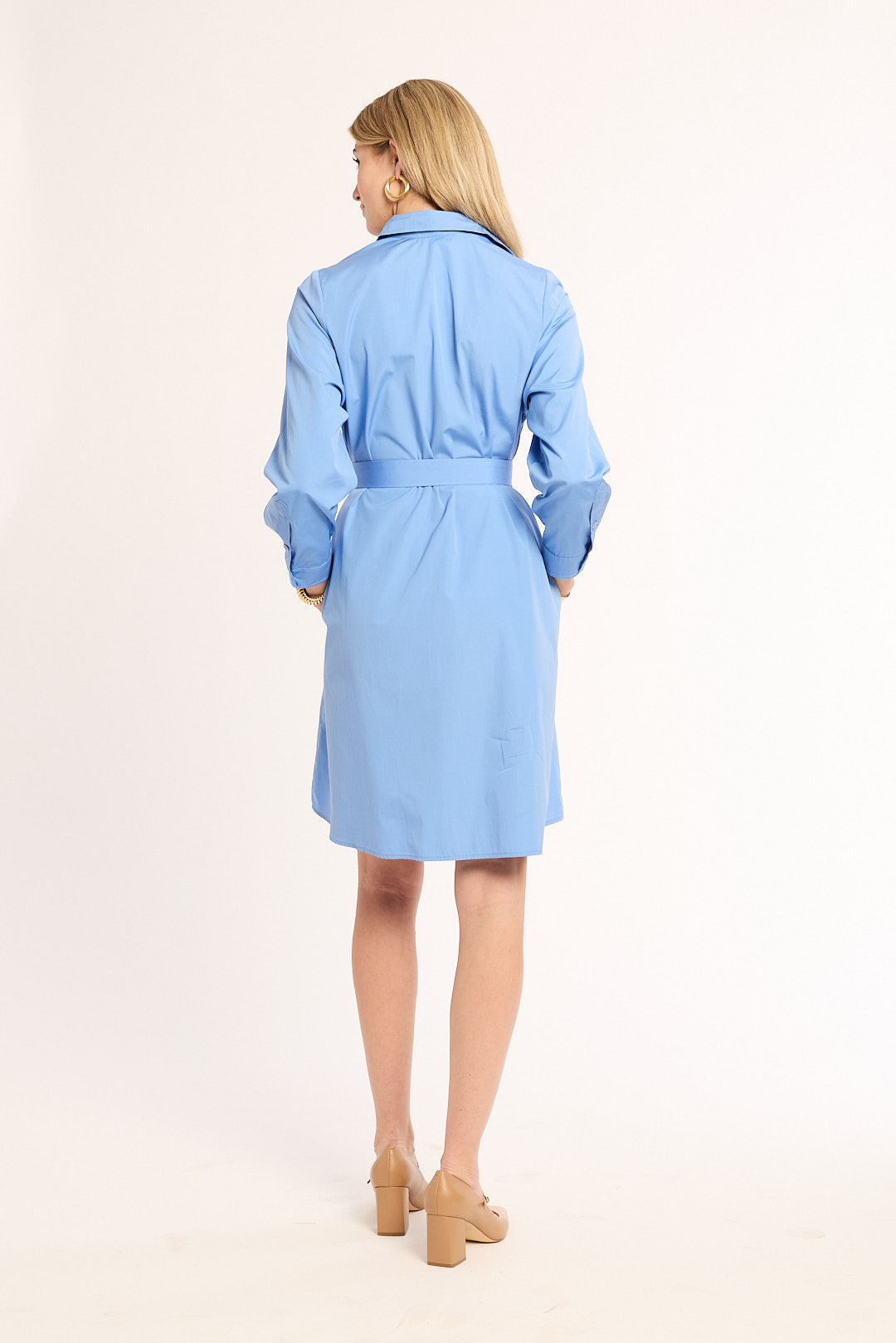 Woman wearing a light blue trench coat on a white background