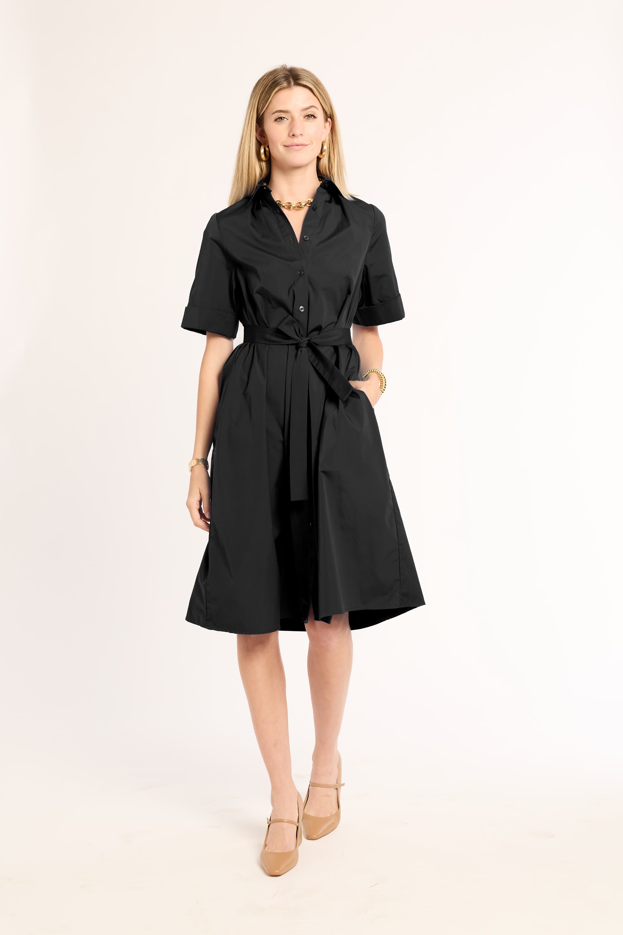 Woman wearing a black dress with a belt on a white background