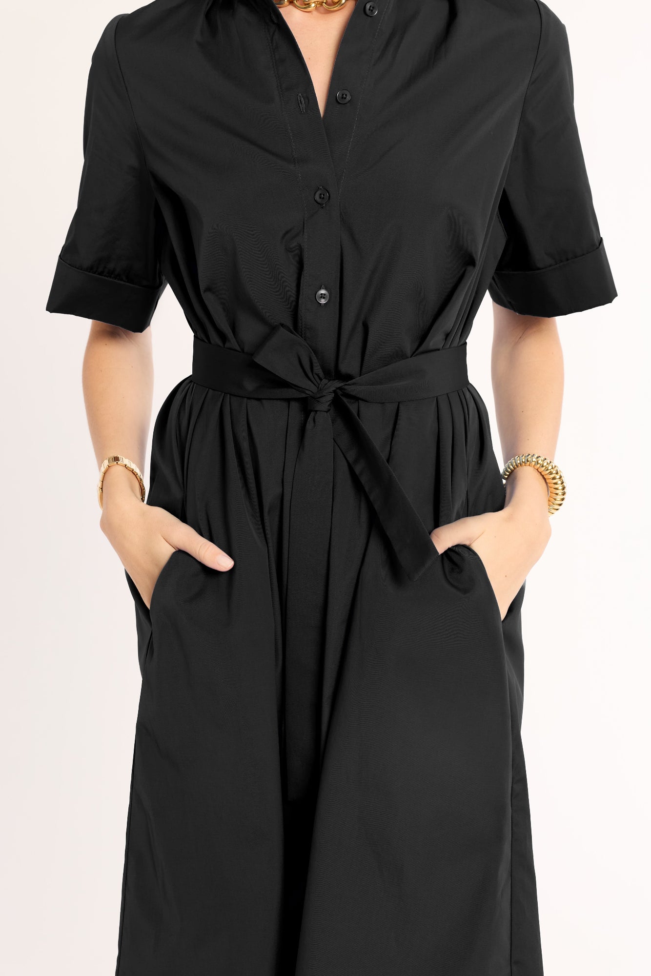 Black dress with a belt on a plain background