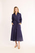 Woman wearing a navy dress with a belt on a white background