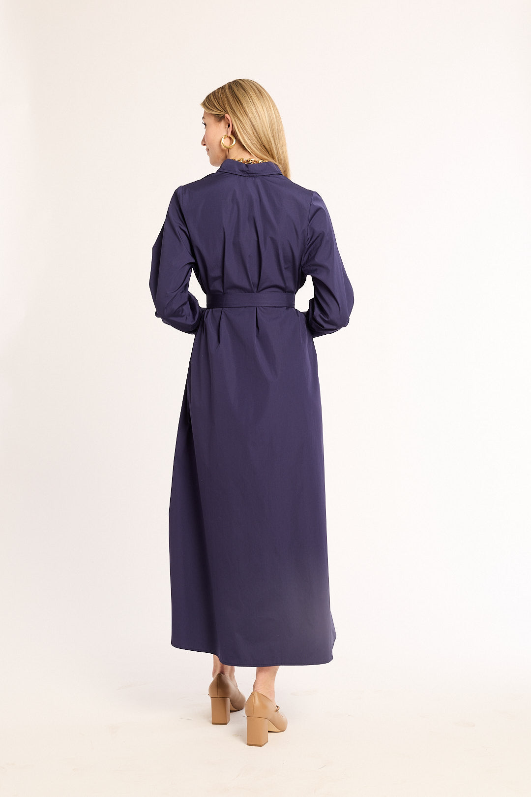 Woman wearing a long navy dress on a white background
