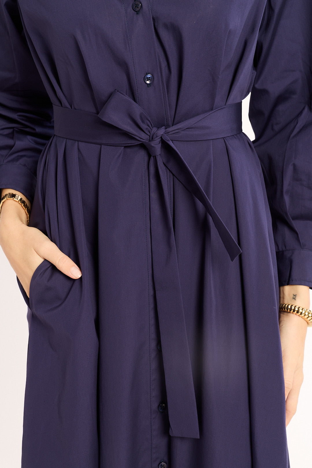 Navy blue dress with a belt on a plain background