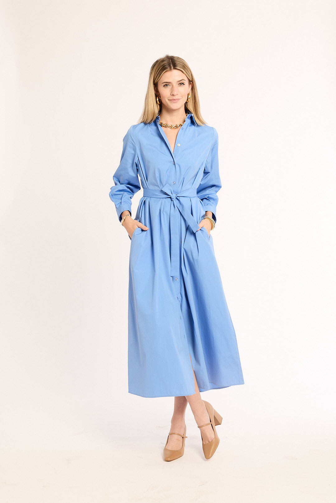 Woman wearing a blue dress with a belt on a white background