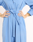 Light blue dress with a tie waist worn by a person on a white background